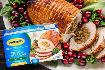 Butterball stuffed turkey package in front of a cooked stuffed turkey roast